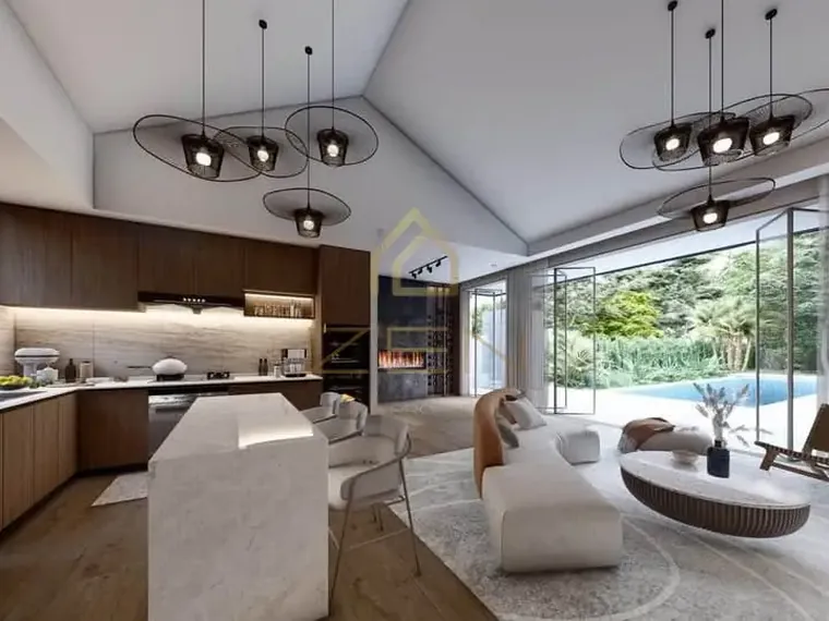 Open kitchen and living room under a vaulted ceiling with pendant lights, glass doors to the pool.