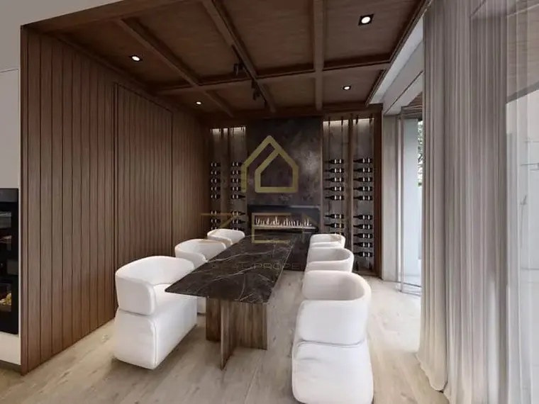 Dining area with timber-panelled walls and white upholstered chairs.