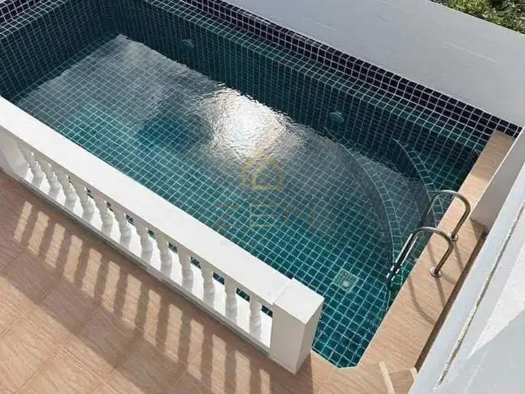 Small dark-tiled pool seen from above, edged by a white balustrade.