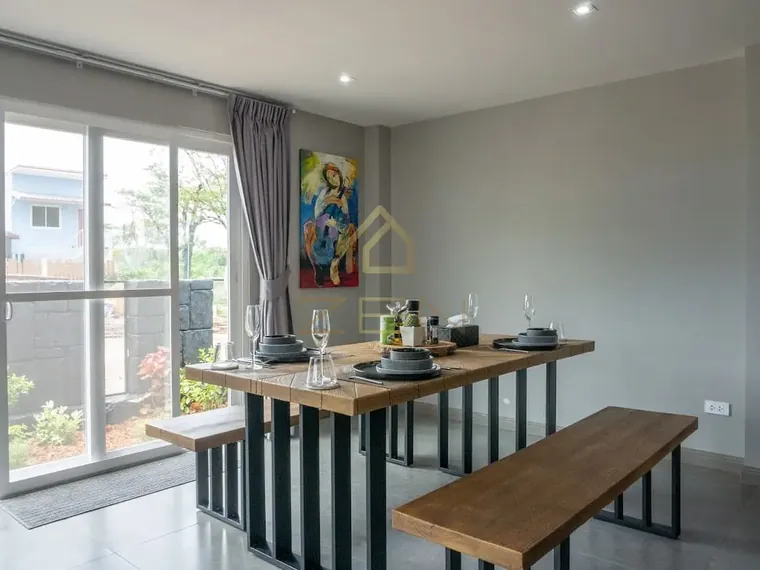 Dining table with benches beside full-height glass doors, a painting on the wall.