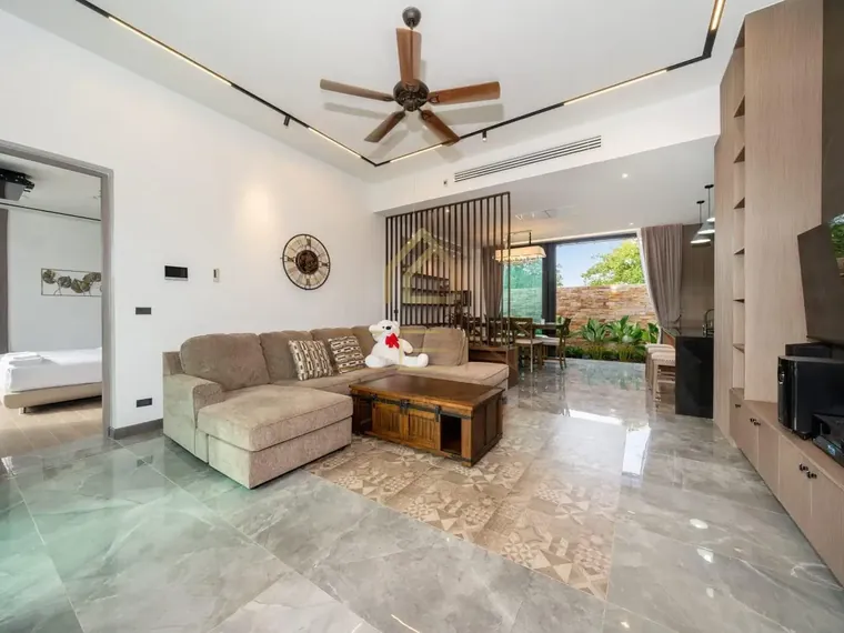 Living room with a ceiling fan, marble floor and a slatted timber feature wall.