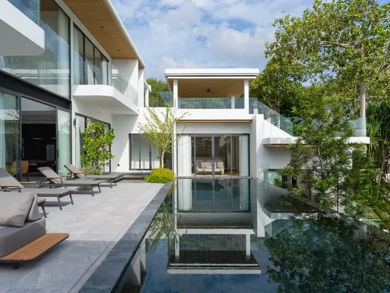 The pool wing seen along the water, with a glass-walled room at the far end.