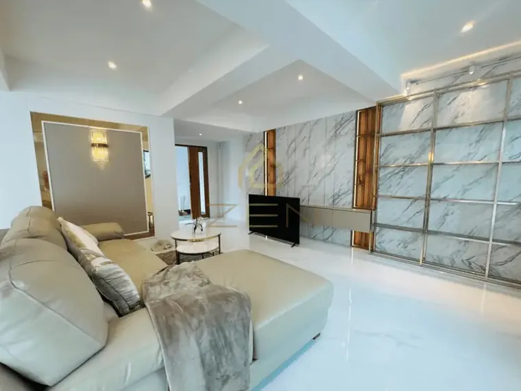 Living room in white marble with a corner sofa.